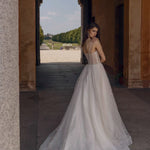 A-line bespoke wedding gown with a sheer corset bodice, spaghetti straps, and shimmering linear tulle embroidery