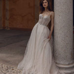 A-line Anetta wedding dress with a beaded bustier bodice and shimmering geometric tulle, handcrafted bridal gown