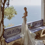 Shimmering mermaid wedding dress with intricate beadwork and a ruffled tulle train, bespoke bridal gown