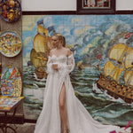 Off-the-shoulder lace A-line bespoke Ricca Sposa Maia gown with puff sleeves and leg slit handcrafted wedding dress
