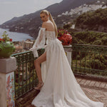 Lace A-line wedding gown with bespoke corset bodice, sheer off-the-shoulder puff sleeves, and high leg slit bridal gown
