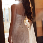 Handcrafted lace wedding gown with corset back and sheer cape, a bespoke Ricca Sposa Elisanne bridal gown