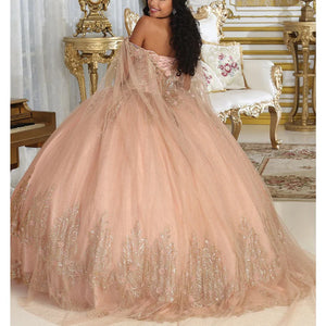 Bespoke blush Quinceañera ball gown with gold lace and off-the-shoulder cape, handcrafted bridal gown