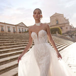 Handcrafted plunging strapless beaded mermaid gown with ethereal overskirt, a Ricca Sposa wedding dress