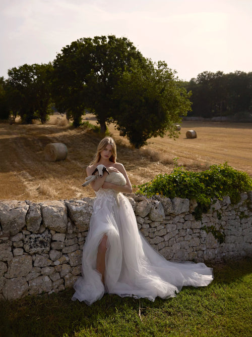 Strapless A-line tulle wedding gown with floral lace appliques and a high leg slit, handcrafted bridal gown