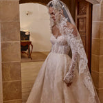 Bespoke A-line lace bridal gown with sheer corset bodice and long sleeves, handcrafted floral wedding dress