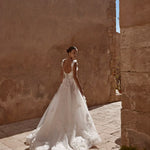 Floral A-line bridal gown with 3D appliqués, low corset back, and long tulle train bespoke wedding dress