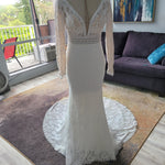 Lace mermaid wedding dress with long sleeves, deep plunging neckline, and crochet trim, bespoke bridal gown