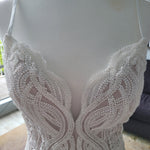 Handcrafted beaded lace mermaid wedding dress with a deep plunging neckline and straps, bespoke bridal gown
