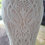 Intricate beaded mermaid wedding dress with geometric patterns and floral embroidery, handcrafted bridal gown