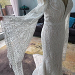 Boho mermaid wedding dress with deep plunging neckline, fringed bell sleeves and handcrafted lace, bespoke bridal gown